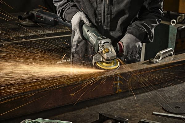 Flap disc on angle grinder in use on a metal