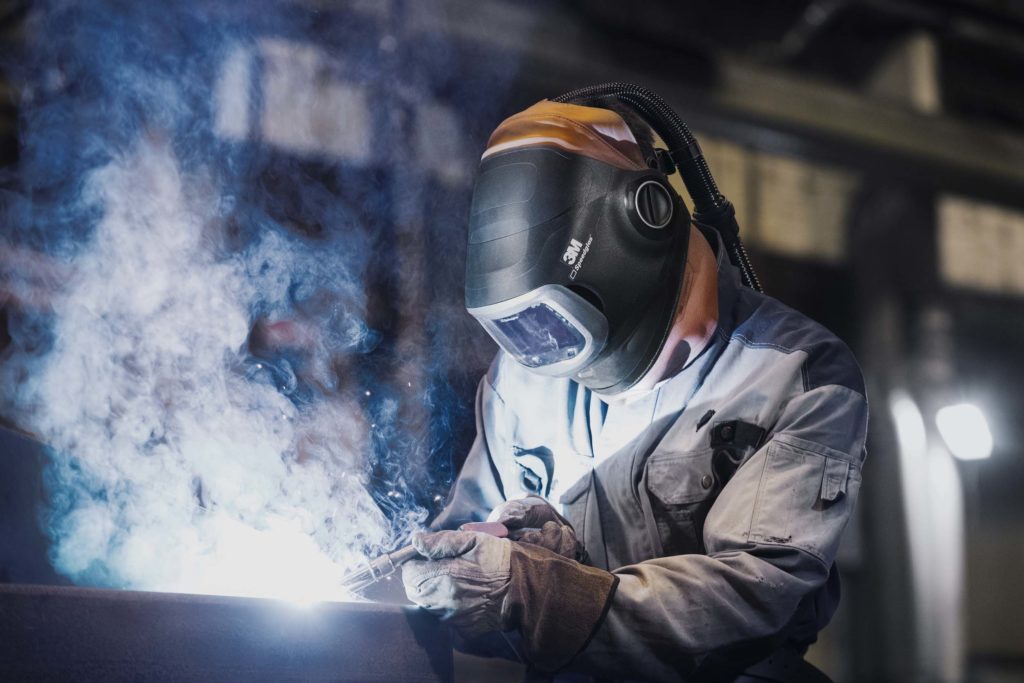 Welding stainless steel PPE including air fed welding helmet, welding gloves, and welding jacket.